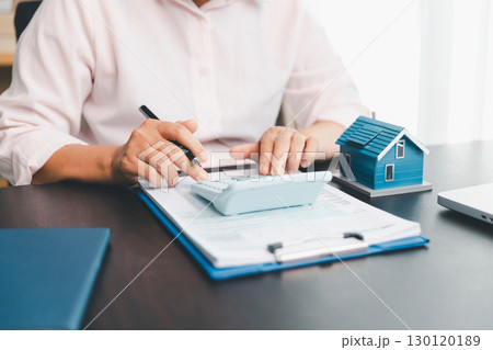 Calculator to check and summary expense of home loan mortgage for refinance plan , people lifestyle concept. Home agents are using calculator to calculate the loan period each month for customer. Calculator to check and summary expense of home loan mortgage for refinance plan , people lifestyle concept. Home agents are using calculator to calculate the loan period each month for customer. 130120189