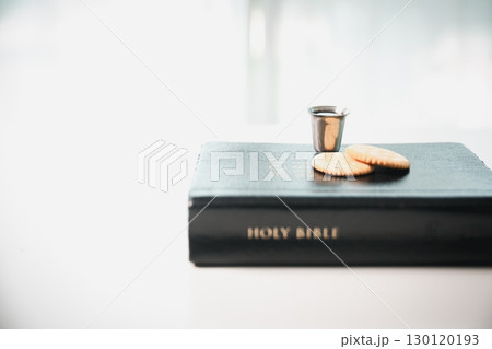 Christianity, holy communion ceremony is sacred act of worship and faith, where bread and wine in chalice symbolize body and blood of Christ in the religious eucharist tradition. 130120193