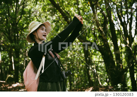Young female traveler with backpack walking in national park or forest. recreation sport in nature. Female person bag, wave for hiking journey in woods. adventure in forest. trekking with backpack Young female traveler with backpack walking in national park or forest. recreation sport in nature. Female person bag, wave for hiking journey in woods. adventure in forest. trekking with backpack 130120383