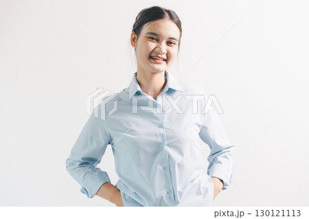 Asian woman rejoicing, looking happy, champion, fist pump gesture, standing over white background. young woman had happy, positive expression on her face, highlighted by bright smile. 130121113