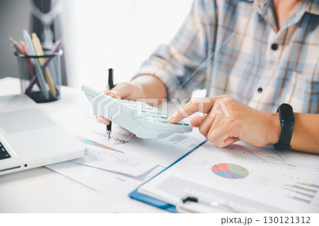 Accountant working on desk using calculator for calculate finance report in office. business finance, calculate tax by organizing financial documents, tracking income investment, accounting by hand. Accountant working on desk using calculator for calculate finance report in office. business finance, calculate tax by organizing financial documents, tracking income investment, accounting by hand. 130121312