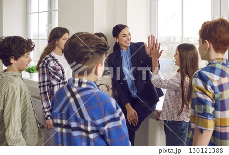 Happy female teacher giving high five to girl student Happy female teacher giving high five to girl student 130121388