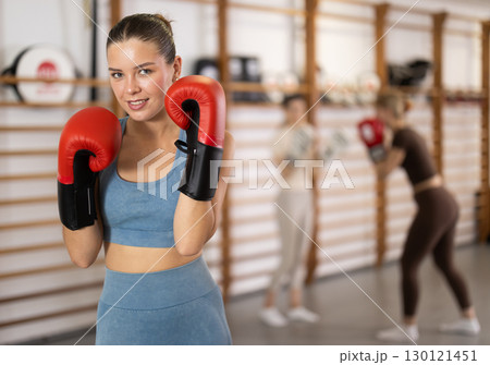 Woman in red boxing gloves in gym 130121451