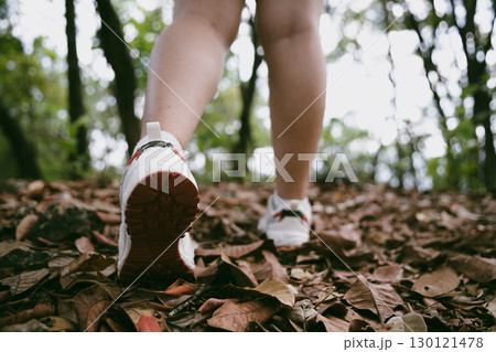 Hiking action on mountain grass trail path. Close up of female hiker shoe. adventurous lifestyle of hiker and backpack to travel and trek mountain, enjoy every walk and hike part of thrilling journey 130121478