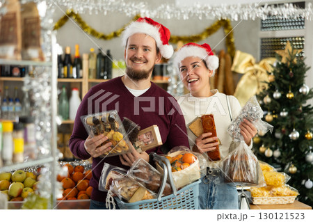 Preparing for Christmas celebration - happy family buys nougat, panettone, marzipan, panellets Preparing for Christmas celebration - happy family buys nougat, panettone, marzipan, panellets 130121523