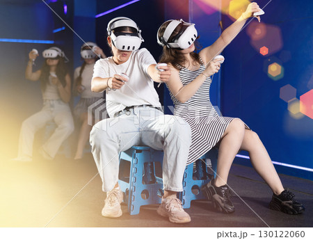 Female friends playing pair versus pair virtual reality game 130122060