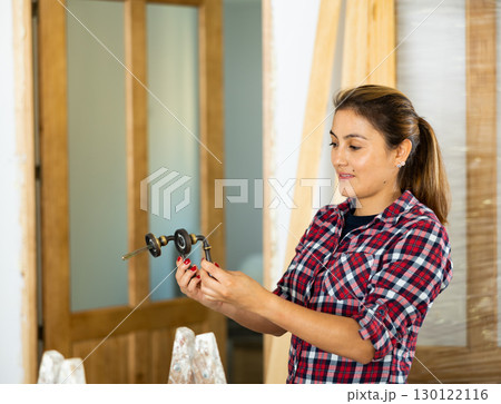 Woman assembling door handle Woman assembling door handle 130122116