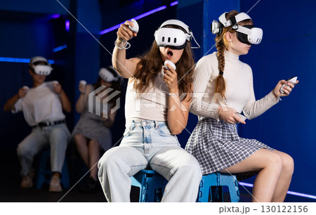 Female friends competing in two-on-two virtual reality game 130122156