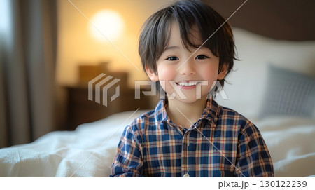 寝室で笑顔を浮かべるパジャマ姿の男の子 130122239