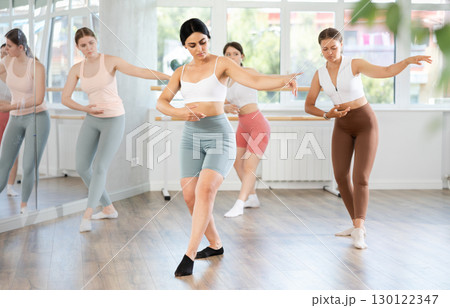 Group of oung ballerinas rehearsing ballet movements in the choreography studio Group of oung ballerinas rehearsing ballet movements in the choreography studio 130122347
