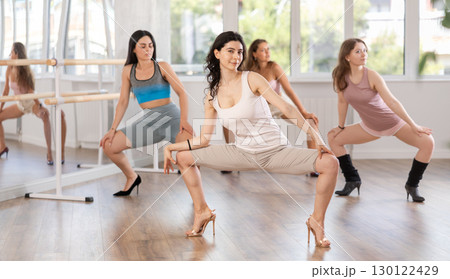 Girls in heels learn to move to beat of music and combine rhythm and smooth movements 130122429