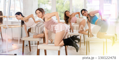 Slender women rehearse modern dances using chair 130122478