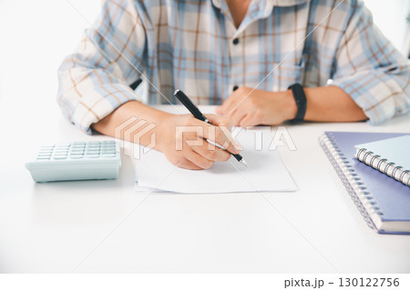 Accountant working on desk using calculator for calculate finance report in office. business finance, calculate tax by organizing financial documents, tracking income investment, accounting by hand. 130122756