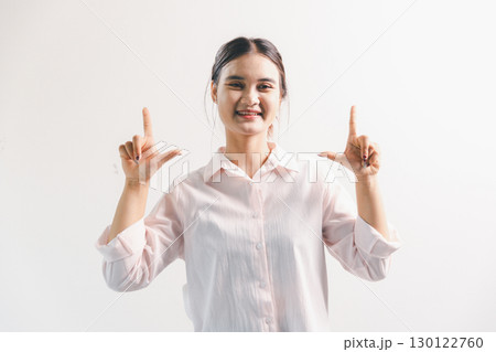 Asian woman rejoicing, looking happy, champion, fist pump gesture, standing over white background. young woman had happy, positive expression on her face, highlighted by bright smile. 130122760