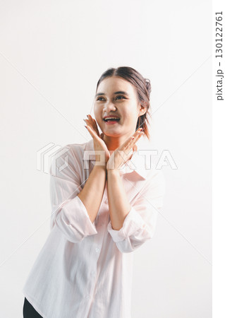 Asian woman rejoicing, looking happy, champion, fist pump gesture, standing over white background. young woman had happy, positive expression on her face, highlighted by bright smile. 130122761