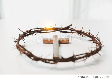Cross and crown of thorns, often seen in gold crucifix symbols, represent the sacrifice of Jesus Christ-central to Easter message and the foundation of faith in the Christian religion. 130122926