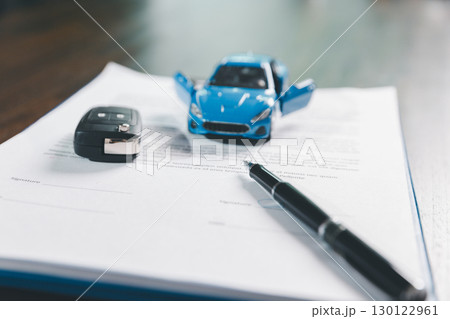 Client legal contract and finance document for business deal involving vehicle, agreements cover car loan, insurance, investment terms, with car key handed over to complete transaction. 130122961