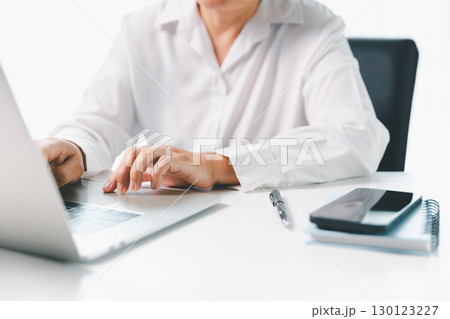 Close-up businesswoman using smart mobile phone at office table, female student is home studying online e-learning, searching for information on internet, engaging with social networks. Close-up businesswoman using smart mobile phone at office table, female student is home studying online e-learning, searching for information on internet, engaging with social networks. 130123227