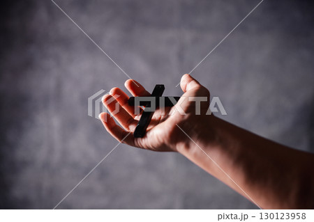 Christian woman lifts her hand in worship to pray, hope, faith, and deep belief in God defines core concept of religion. Praying hands with faith in religion, belief in God. Power of hope or love. 130123958