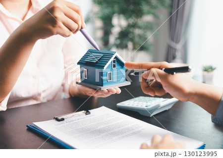 Woman real estate sale agent, client after signing agreement contract real estate with approved mortgage application form concerning mortgage loan offer, house insurance. contract agreement in office Woman real estate sale agent, client after signing agreement contract real estate with approved mortgage application form concerning mortgage loan offer, house insurance. contract agreement in office 130123995