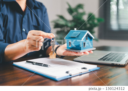 Female hand holds small miniature toy house, symbolizing woman dream of moving into her own home-real estate concept represents property investment, mortgage planning, insurance for secure future. Female hand holds small miniature toy house, symbolizing woman dream of moving into her own home-real estate concept represents property investment, mortgage planning, insurance for secure future. 130124312