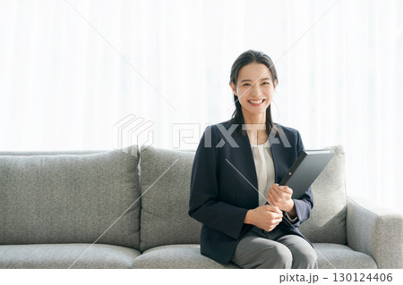 ソファに座るスーツ姿の女性 ソファに座るスーツ姿の女性 130124406