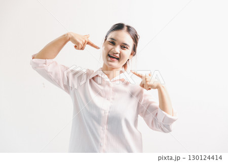 Asian woman rejoicing, looking happy, champion, fist pump gesture, standing over white background. young woman had happy, positive expression on her face, highlighted by bright smile. Asian woman rejoicing, looking happy, champion, fist pump gesture, standing over white background. young woman had happy, positive expression on her face, highlighted by bright smile. 130124414