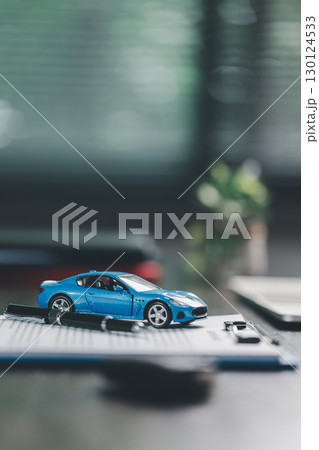 Car loan approval concept. Client finalizes purchase of vehicle by signing contract includes auto loan, insurance, credit terms, making car smart financial investment business-backed finance option. 130124533