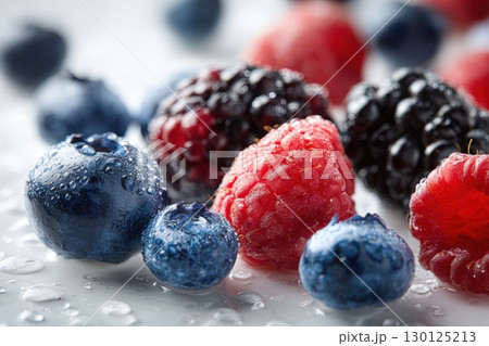 Macro Shot of Fresh Blueberries, Raspberries, and Blackberries with Water Droplets 130125213