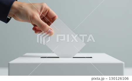 Hand inserting blank ballot paper into white voting box, symbolizing democratic participation and decision making 130126106