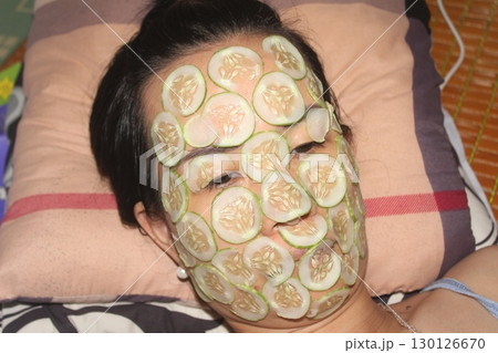 August 18, 2025. Chu Van An, Hai Phong, Viet Nam. girl beautifies facial skin with cucumber August 18, 2025. Chu Van An, Hai Phong, Viet Nam. girl beautifies facial skin with cucumber 130126670