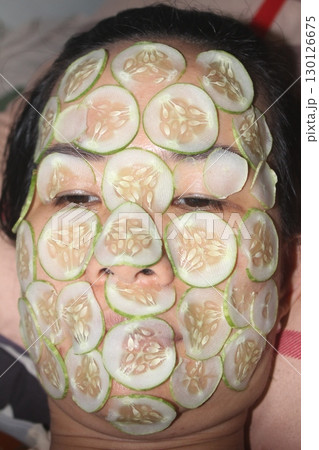 August 18, 2025. Chu Van An, Hai Phong, Viet Nam. girl beautifies facial skin with cucumber August 18, 2025. Chu Van An, Hai Phong, Viet Nam. girl beautifies facial skin with cucumber 130126675