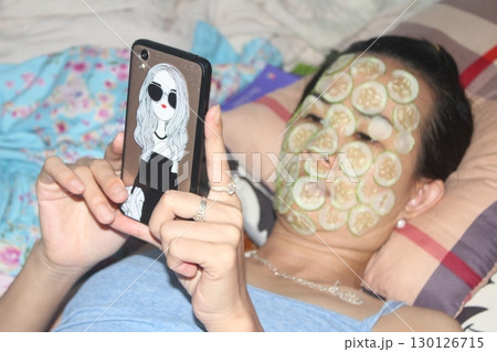 August 18, 2025. Chu Van An, Hai Phong, Viet Nam. girl beautifies facial skin with cucumber 130126715