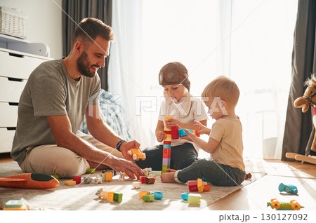 Construction toys. Father is playing with two little boys on the floor 130127092