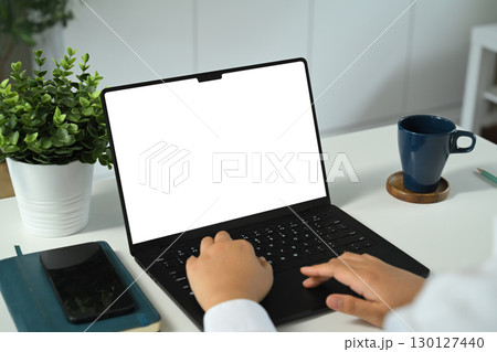 Hands typing on laptop with blank white screen mockup, for website Hands typing on laptop with blank white screen mockup, for website 130127440