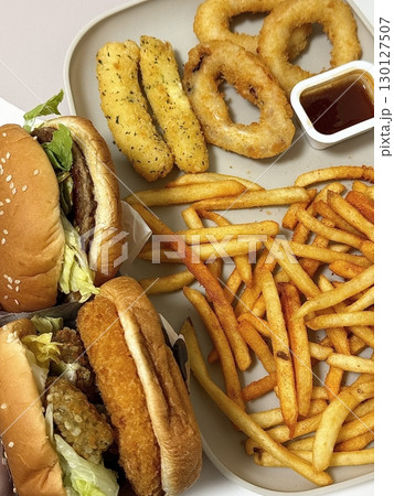 A classic combination of a juicy burger with fresh toppings served alongside golden, crispy French fries. Perfect for a satisfying meal that blends savory flavors and crunchy textures. 130127507