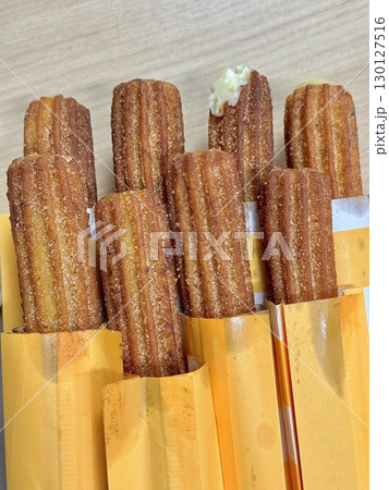 Churros, crispy and golden, dusted with sugar and cinnamon. A delicious, sweet treat often enjoyed with chocolate dipping sauce, perfect for satisfying any dessert craving. 130127516