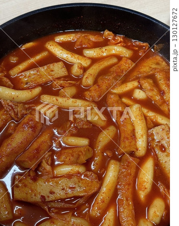 Spicy Korean tteokbokki with chewy rice cakes in a vibrant red sauce, topped with sesame seeds and green onions. A popular street food known for its addictive flavor and satisfying texture. Spicy Korean tteokbokki with chewy rice cakes in a vibrant red sauce, topped with sesame seeds and green onions. A popular street food known for its addictive flavor and satisfying texture. 130127672