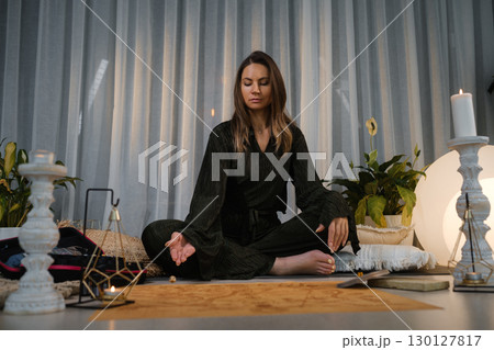 Meditation practice in a serene indoor space with natural light and calming decor in the early morning hours Meditation practice in a serene indoor space with natural light and calming decor in the early morning hours 130127817
