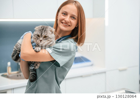 After the check up, holding and smiling. Scottish fold cat in the veterinarian clinic with female doctor After the check up, holding and smiling. Scottish fold cat in the veterinarian clinic with female doctor 130128064