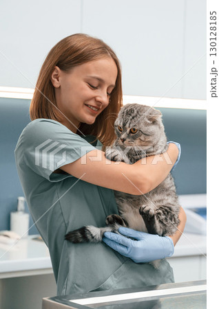 Holding in hands, smiling. Scottish fold cat in the veterinarian clinic with female doctor 130128185