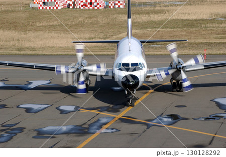 正面から見た秋の空港に到着したプロペラ機 130128292