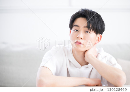 頬杖をつく考える表情のカメラ目線の男性のクローズアップ 頬杖をつく考える表情のカメラ目線の男性のクローズアップ 130128469