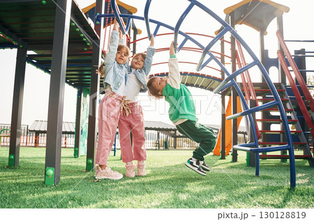Beautiful sunlight. Kids are having fun on the playground 130128819