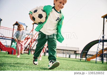 Boy is with soccer ball. Kids are having fun on the playground Boy is with soccer ball. Kids are having fun on the playground 130128832