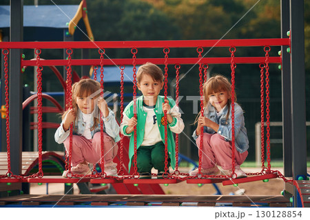 One boy and two girls. Kids are having fun on the playground 130128854
