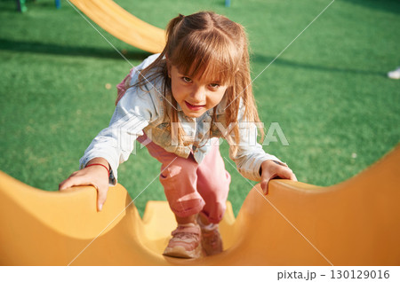 On a playground slide. Little girl is having fun on On a playground slide. Little girl is having fun on 130129016
