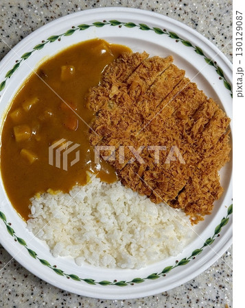 Crispy tonkatsu, a Japanese-style breaded and deep-fried pork cutlet, served with shredded cabbage and drizzled with savory sauce. A delightful balance of crunchy texture and juicy meat. 130129087