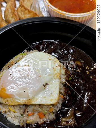 A bowl of jajangmyeon featuring chewy noodles coated in rich black bean sauce, topped with diced pork and vegetables. This iconic Korean-Chinese dish offers a savory and hearty flavor. A bowl of jajangmyeon featuring chewy noodles coated in rich black bean sauce, topped with diced pork and vegetables. This iconic Korean-Chinese dish offers a savory and hearty flavor. 130129091