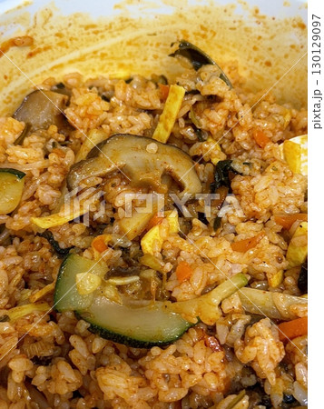 Bibimbap, a vibrant Korean rice dish topped with a variety of seasoned vegetables, gochujang, and a fried egg, often accompanied by sliced meat. Mixed together, it creates a flavorful and balanced. 130129097